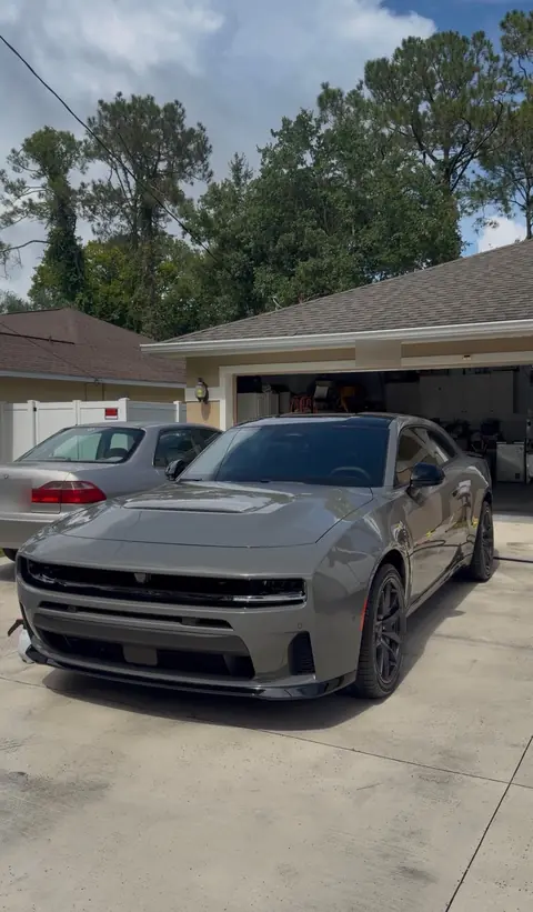 Gray Dodge Charger in a driveway after a detail