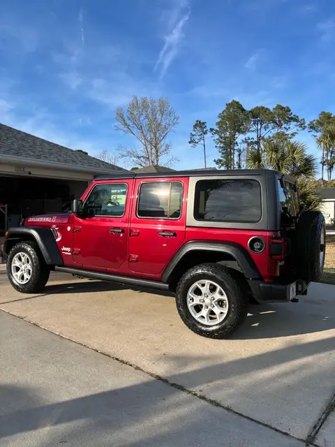 Red four-door Jeep Wrangler parked in a driveway after an exterior detail